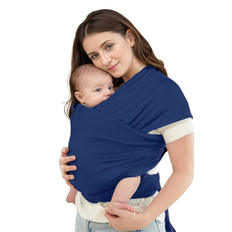 Mother wearing navy blue baby wrap carrier with infant secured in comfortable position, white background