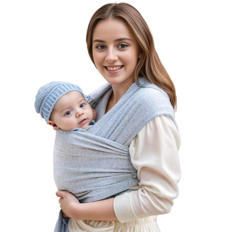Mother wearing light gray baby wrap carrier with infant in knit hat, showing breathable fabric texture